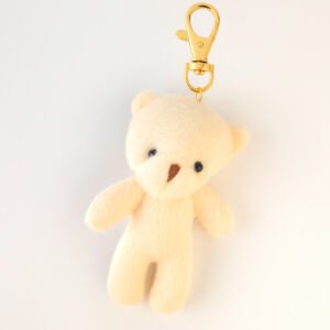 Llavero de peluche en tono crema con clip dorado, complemento ideal para cajas de regalo Pepa Brown.