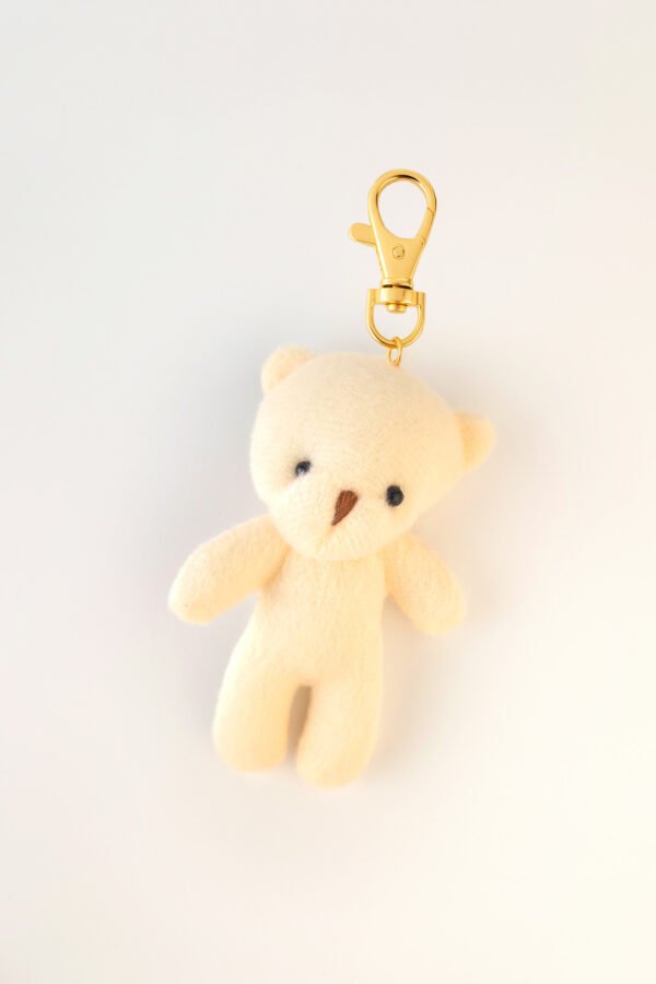 Llavero de peluche en tono crema con clip dorado, complemento ideal para cajas de regalo Pepa Brown.